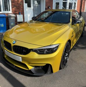 Austin yellow BMW car. fully cleaned and detailed. showing mirror like reflective paintwork finish